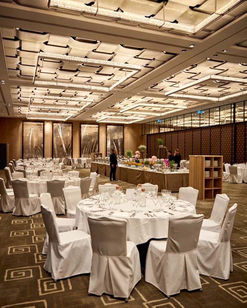 An elegant event dining room set with round tables and a buffet